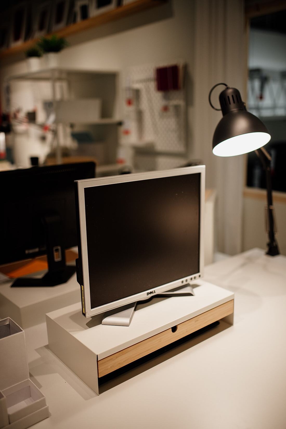A workspace with a computer monitor and desk lamp